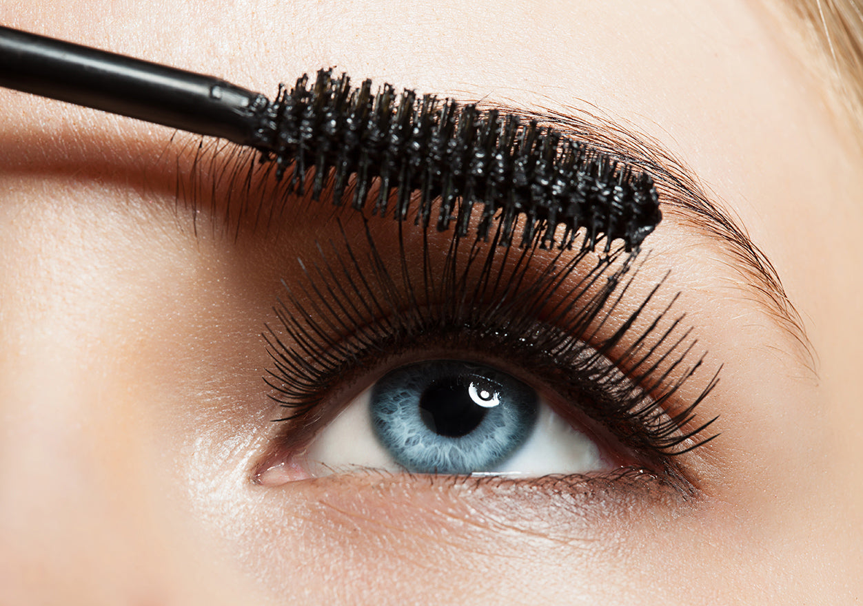 Bild eines Auges, das das Auftragen von Mascara auf die Wimpern zeigt.