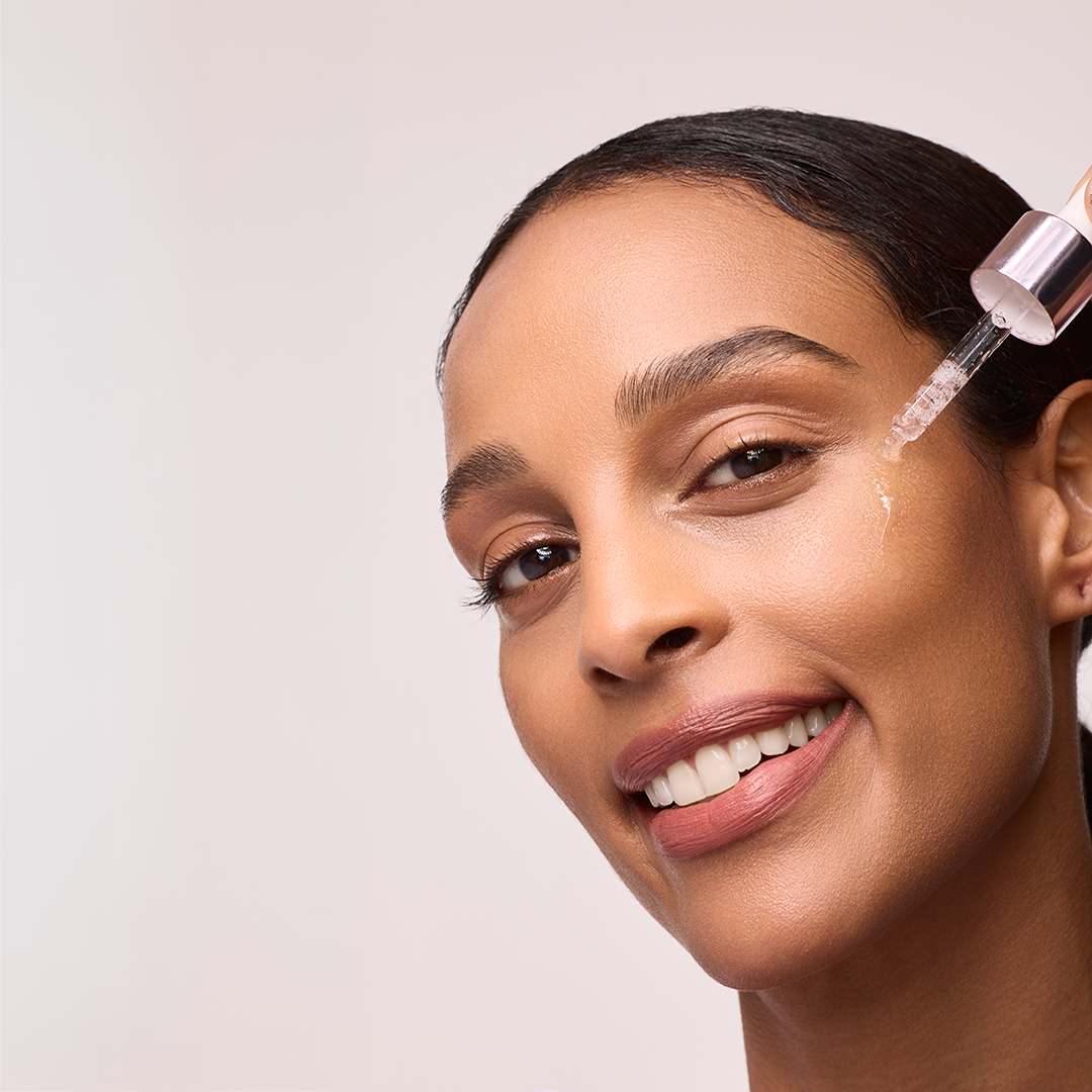 Model trägt mit Pipette Gesichtspeeling auf