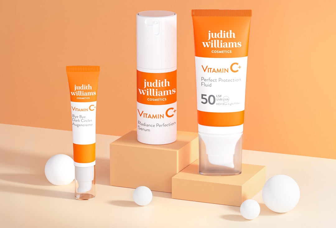weiß orange Vitamin C Produkte auf Plattformen vor einem orangen Hintergrund