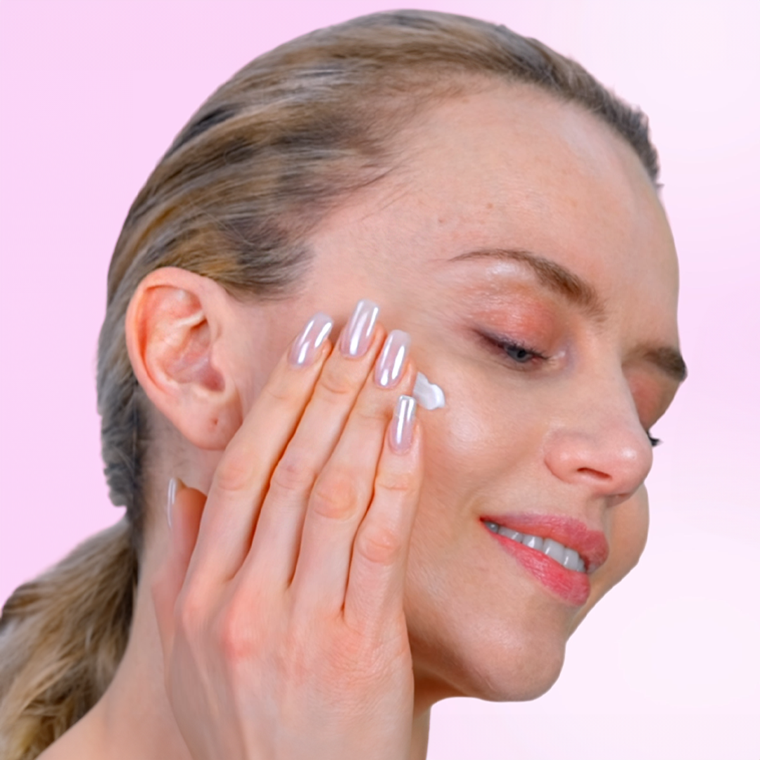 Model das Gesichtscreme auf ihre Wangen aufträgt.