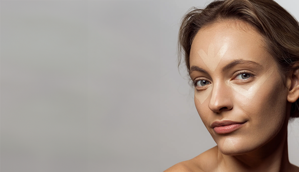 Model mit Concealer auf der Stirn und unter den Augen