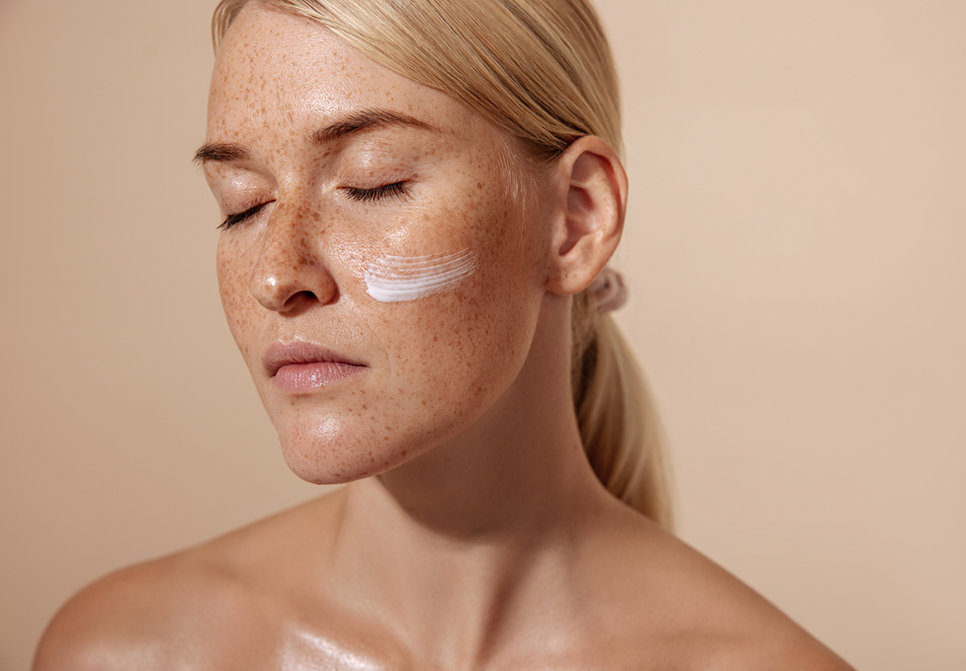 Model mit Gesichtscreme auf den Wangen