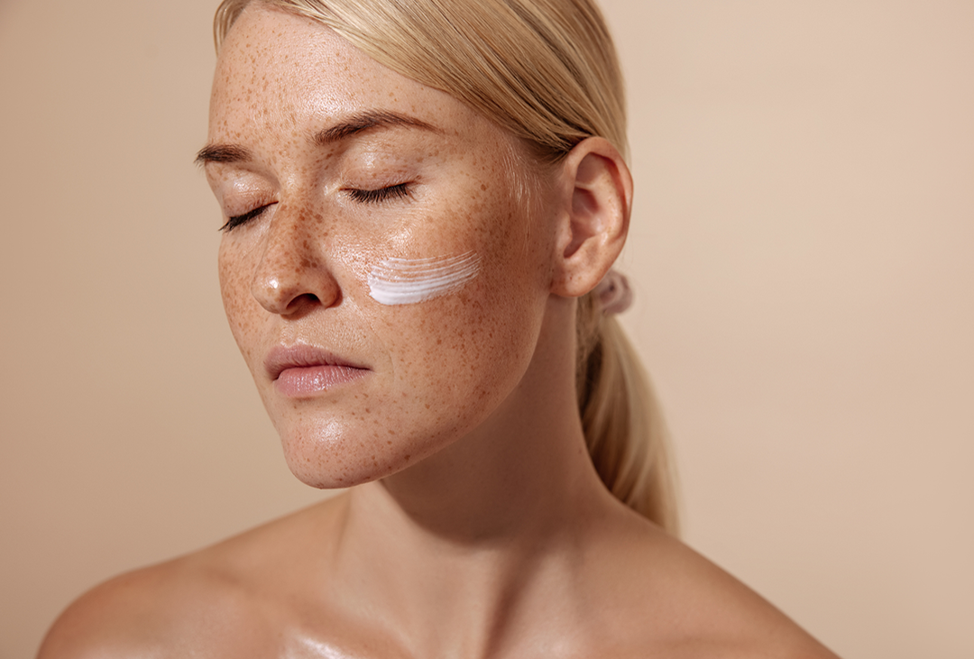 Model mit Gesichtscreme auf den Wangen