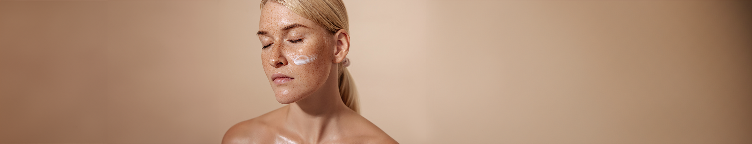 Model mit Gesichtscreme auf den Wangen