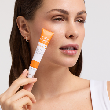 Model mit Vitamin C+ Augencreme in der Hand