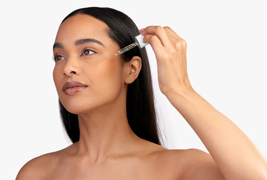 Junge Frau, die eine Ampulle aufträgt 