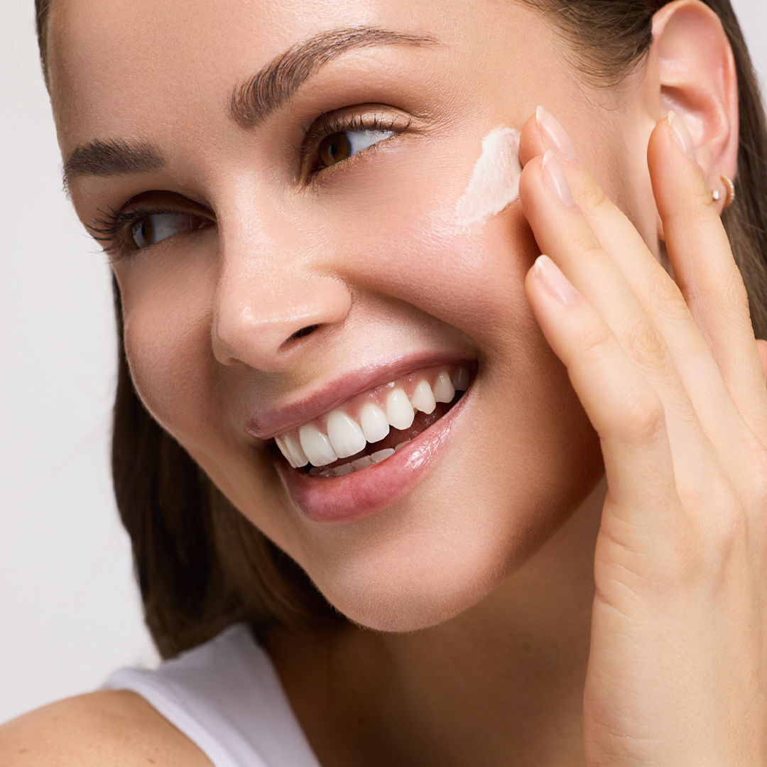 Model, dass sich das Vitamin C+ Perfect Protection Fluid aufträgt.